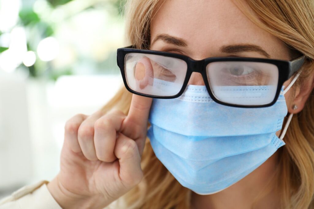 a woman wearing a face mask and foggy glasses